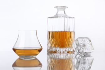 bottle and glass of brandy on a white background